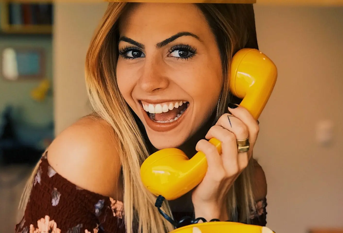 woman holding yellow rotary telephone